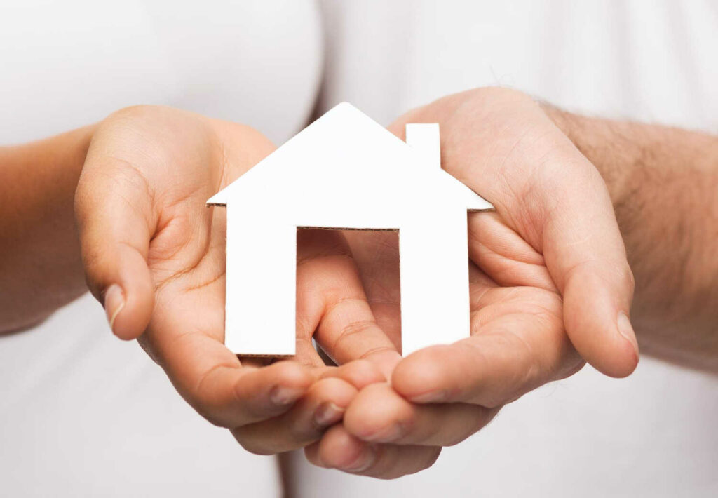 real-estate-family-concept-closeup-couple-hands-holding-paper-house