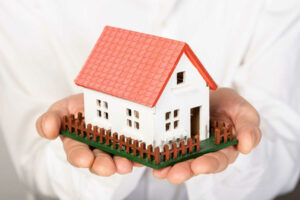 toy-model-house-held-hands-close-up